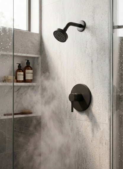 Onyx Elements matte black modern shower faucet and head set installed in a minimalist marble tiled shower.